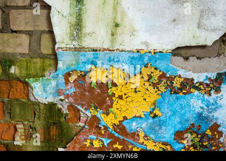 Texture d'un vieux mur de briques blanches cassées avec du plâtre effrayant et de la peinture colorée pelée Banque D'Images