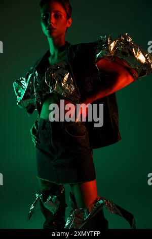 Une femme dans une tenue de mode durable pose sous un éclairage vert et rouge. Banque D'Images