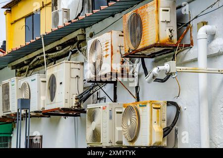 Vieilles unités de climatisation altérées sur le mur extérieur d'un bâtiment à Penang, Malaisie Banque D'Images