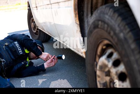 Hambourg, Allemagne. 30 juillet 2024. Un policier vérifie une voiture pour déceler des défauts techniques dans le district de Bahrenfeld. Lors d'un contrôle à grande échelle, la police a vérifié le respect des règles de sécurité routière. Crédit : Daniel Bockwoldt/dpa/Alamy Live News Banque D'Images