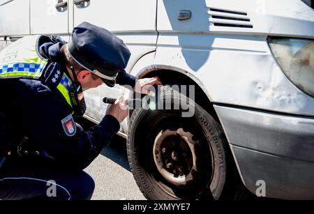 Hambourg, Allemagne. 30 juillet 2024. Un policier vérifie une voiture pour déceler des défauts techniques dans le district de Bahrenfeld. Lors d'un contrôle à grande échelle, la police a vérifié le respect des règles de sécurité routière. Crédit : Daniel Bockwoldt/dpa/Alamy Live News Banque D'Images