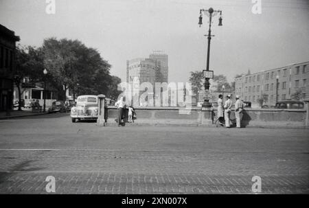 Années 1950, historique, scène de rue, Birmingham, Alabama, USA, voitures garées et les gens du coin debout près d'un pont. Un grand panneau au loin indique «la ville magique», un nom qui a été utilisé en raison de sa croissance spectaculaire (comme par magie) comme une nouvelle ville des années 1880 aux années 1920 Le Bankhead Hotel peut également être vu au loin. Construit en 1926 et nommé d'après le sénateur John H. Bankhead, l'hôtel était un immeuble de 15 étages construit près de la gare de Birmingham. Banque D'Images