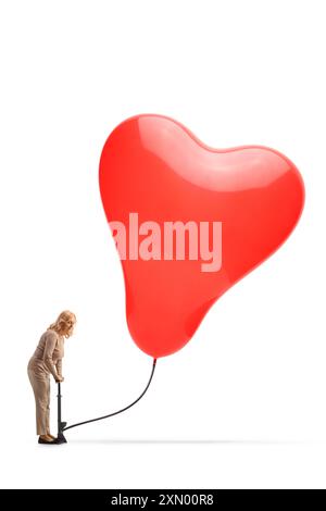 Femme utilisant une pompe manuelle et pompant un ballon en forme de coeur isolé sur fond blanc Banque D'Images