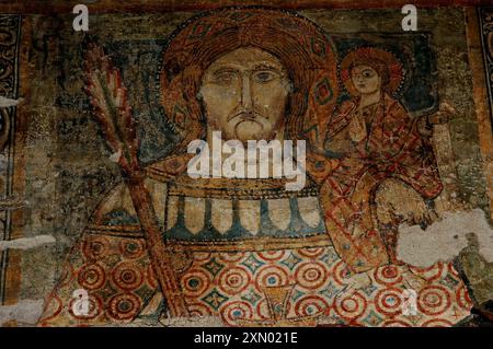 Saint Christophe et le Christ enfant portent des vêtements à motifs aux couleurs vives dans cette fresque médiévale de style byzantin dans la Basilique-Duomo di San Vigilio à trente, en Italie. Banque D'Images
