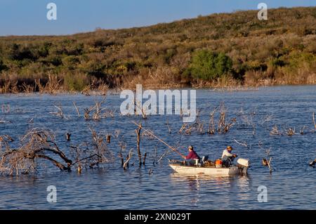 Pêcheurs en bateau près de Frio Bend Ramp, Choke Canyon Reservoir, Choke Canyon State Park, près du coucher du soleil, printemps, South Texas Region, Texas, ÉTATS-UNIS Banque D'Images