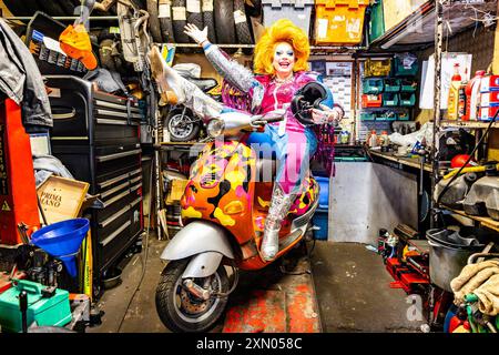 Édimbourg, Royaume-Uni. 30 juillet, 2024 photo : Ginger Johnson chevauche un cyclomoteur coloré dans un atelier de moto. Reine régnante de RuPaul's Drag Race UK, la célèbre performeuse Ginger Johnson, échange sa couronne contre un casque de crash alors qu'elle présente son tout nouveau spectacle Ginger Johnson Blows Off ! Vers Edinburgh Fringe 2024.. Crédit : Rich Dyson/Alamy Live News Banque D'Images