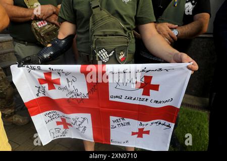 KIEV, UKRAINE - 29 JUILLET 2024 - le drapeau de la Géorgie est vu entre les mains d'un participant au rassemblement contre les mesures répressives contre les volontaires militaires géorgiens, qui ont combattu aux côtés de l'Ukraine dans la guerre russo-ukrainienne, devant l'ambassade de Géorgie à Kiev, capitale de l'Ukraine Banque D'Images