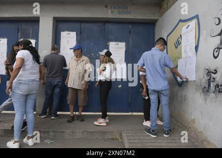 Les gens recherchent leurs noms sur les listes électorales lors des élections présidentielles vénézuéliennes. Des centaines de personnes sont descendues dans la rue pour protester dans l'après-midi du 29 juillet, après que le Conseil électoral national (CNE) ait annoncé la veille que le candidat vénézuélien et président Nicolás Maduro était le « vainqueur irréversible ». Le rassemblement a commencé dans l'un des quartiers les plus emblématiques de la ville, 'El Petare'. Les chants exprimaient leur insatisfaction à l'égard du résultat. La situation s'est aggravée lorsque la Garde nationale bolivarienne est venue arrêter l'avancée des manifestants. Banque D'Images