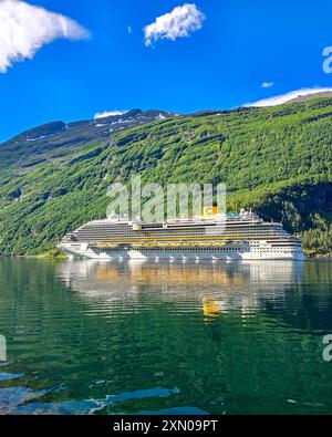 Geiranger fjord Norvège 10 juillet 2024, Un navire de croisière colossal navigue gracieusement sur les eaux tranquilles des fjords norvégiens, entouré de montagnes verdoyantes et d'un ciel clair. Banque D'Images