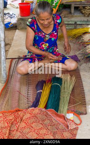 Femme vietnamienne âgée tissant des nattes de couchage à partir de roseaux séchés et teints au village de Tra Nhieu, Quảng Nam, Centre du Vietnam, Asie en juin Banque D'Images