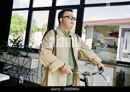 Un jeune homme atteint du syndrome de Down se tient debout avec son vélo, prêt pour une balade. Banque D'Images