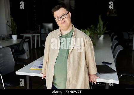 Un homme atteint du syndrome de Down se tient confiant dans un cadre de bureau moderne. Banque D'Images