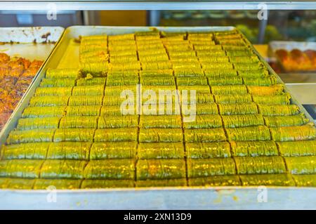 Les rouleaux verts de baklava traditionnel doux et délicieux à la pistache dans l'étal de Cumartesi Bazaar, Antalya, Turquie Banque D'Images