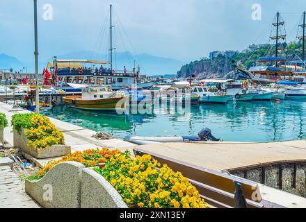 La ligne de petits bateaux de pêche dans la marina d'Antalya contre les silhouettes de montagne brumeuses, Turquie Banque D'Images