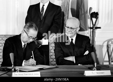 Le premier ministre japonais Nobusuke Kishi signe un traité de coopération mutuelle et de sécurité alors qu’il est assis à côté du président américain Dwight Eisenhower, salle est de la Maison Blanche, Washington, DC, États-Unis, Marion K. Trikosko, collection de photographies du magazine U.S. News & World Report, 19 janvier 1960 Banque D'Images