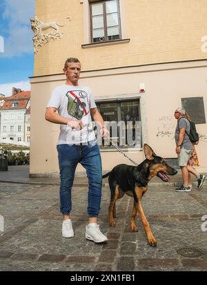 Varsovie, Pologne, 19 avril 2022 : un homme promène un chien de berger dans la vieille ville Banque D'Images