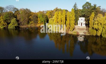 Beau paysage d'automne. Lac, surface lisse de l'eau miroir, bateau blanc, arbres feuilles jaunes, architecture, ciel bleu, garez-vous le jour ensoleillé d'automne. Paysage naturel. Arrière-plan de la nature. Environnement. Antenne Banque D'Images