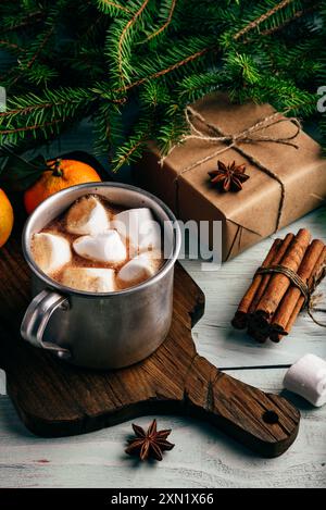 Tasse en métal de chocolat chaud avec guimauves sur planche à découper Banque D'Images