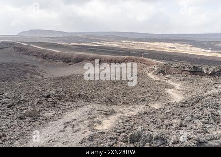 Les débris volcaniques rouges du cratère d’explosion de Garrayto se trouvent à la surface des collines qui divisent Lake, Garrayto, Djibouti Banque D'Images