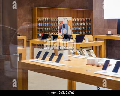 Paris, France - 23 décembre 2023 : intérieur de l'Apple Store avec plusieurs ordinateurs MacBook Pro et étuis pour iPhone exposés, montrant le design élégant du magasin sans que les clients ne soient présents tard dans la nuit Banque D'Images