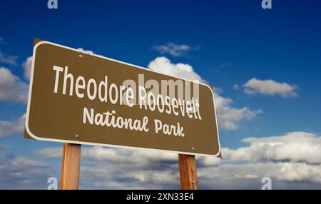 Theodore Roosevelt National Park (Dakota du Nord) panneau routier contre ciel bleu et nuages. Banque D'Images