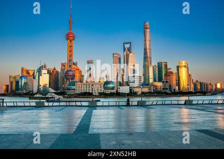 Deux touristes solitaires bravent le coronavirus à Shanghai, généralement animé Bund avec la ligne d'horizon de Pudong derrière. Banque D'Images