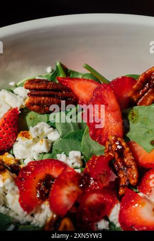 gros plan de salade d'épinards et de fraises avec noix de pécan confites et fromage feta Banque D'Images