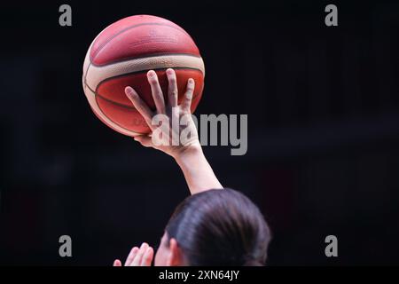 Arbitre Amy Bonner (USA) tenant un ballon de basket-ball avec sa main. Tournoi de qualification olympique FIBA. Pirée 2024. Banque D'Images