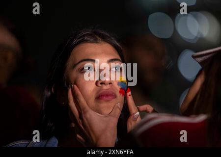 Des partisans vénézuéliens de l’opposition résidant au Mexique manifestent au pied de l’Ange de la Independencia contre la réélection de NICOLAS MADURO, sur leur visage on peut voir les couleurs peintes du Venezuela. Banque D'Images