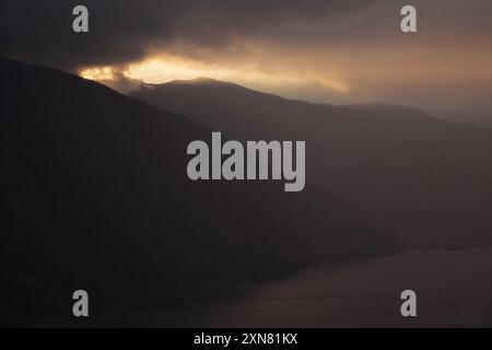 Les montagnes des Cinque Terre enveloppées de brume et de nuages alors que l'aube se lève sur la côte italienne. Banque D'Images