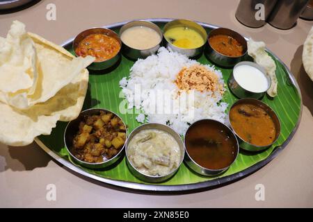 Un thali ou repas sud-indien se compose de riz cuit à la vapeur, sambar, rasam, currys de légumes, Avial, chutney à la noix de coco, cornichons, papadum, caillé ou yaourt Banque D'Images