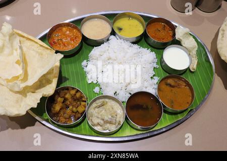 Un thali ou repas sud-indien se compose de riz cuit à la vapeur, sambar, rasam, currys de légumes, Avial, chutney à la noix de coco, cornichons, papadum, caillé ou yaourt Banque D'Images