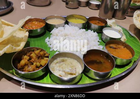 Un thali ou repas sud-indien se compose de riz cuit à la vapeur, sambar, rasam, currys de légumes, Avial, chutney à la noix de coco, cornichons, papadum, caillé ou yaourt Banque D'Images