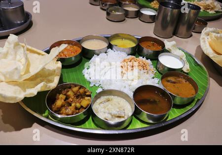 Un thali ou repas sud-indien se compose de riz cuit à la vapeur, sambar, rasam, currys de légumes, Avial, chutney à la noix de coco, cornichons, papadum, caillé ou yaourt Banque D'Images