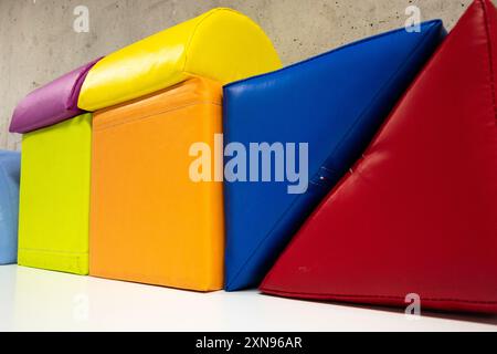 Une rangée de blocs colorés avec un rouge au milieu. Les blocs sont disposés de manière à ressembler à une maison Banque D'Images