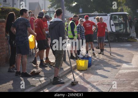 Volontaires sur Sussex Road à Southport, Merseyside, après que des policiers ont été grièvement blessés lorsque des briques, des pierres et des bouteilles ont été lancées et des voitures incendiées lors de violentes manifestations suite à une veillée pour trois filles tuées dans une attaque au couteau dans un club de vacances sur le thème de Taylor Swift lundi. Date de la photo : mercredi 31 juillet 2024. Banque D'Images