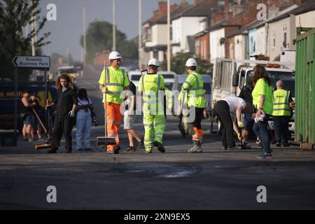 Les travailleurs d'intervention dégagent Sussex Road à Southport, dans le Merseyside, après que des policiers ont été grièvement blessés lorsque des briques, des pierres et des bouteilles ont été lancées et que des voitures ont été incendiées lors de violentes manifestations suite à une veillée pour trois filles tuées dans une attaque au couteau dans un club de vacances sur le thème de Taylor Swift lundi. Date de la photo : mercredi 31 juillet 2024. Banque D'Images