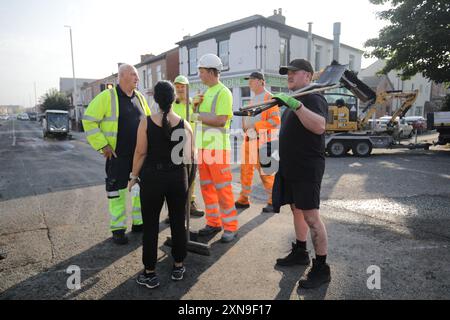 Les travailleurs d'intervention dégagent Sussex Road à Southport, dans le Merseyside, après que des policiers ont été grièvement blessés lorsque des briques, des pierres et des bouteilles ont été lancées et que des voitures ont été incendiées lors de violentes manifestations suite à une veillée pour trois filles tuées dans une attaque au couteau dans un club de vacances sur le thème de Taylor Swift lundi. Date de la photo : mercredi 31 juillet 2024. Banque D'Images