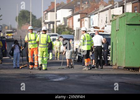 Les travailleurs d'intervention dégagent Sussex Road à Southport, dans le Merseyside, après que des policiers ont été grièvement blessés lorsque des briques, des pierres et des bouteilles ont été lancées et que des voitures ont été incendiées lors de violentes manifestations suite à une veillée pour trois filles tuées dans une attaque au couteau dans un club de vacances sur le thème de Taylor Swift lundi. Date de la photo : mercredi 31 juillet 2024. Banque D'Images