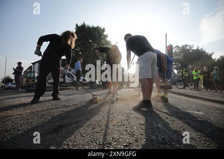 Des volontaires balayent Sussex Road à Southport, Merseyside, après que des policiers ont été grièvement blessés lorsque des briques, des pierres et des bouteilles ont été lancées et que des voitures ont été incendiées lors de violentes manifestations suite à une veillée pour trois filles tuées dans une attaque au couteau dans un club de vacances sur le thème de Taylor Swift lundi. Date de la photo : mercredi 31 juillet 2024. Banque D'Images