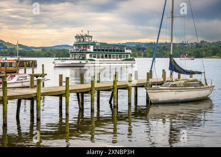 Le bateau à vapeur Windermere The Swift arrive à l'embarcadère d'Ambleside dans la lumière du soir. Banque D'Images