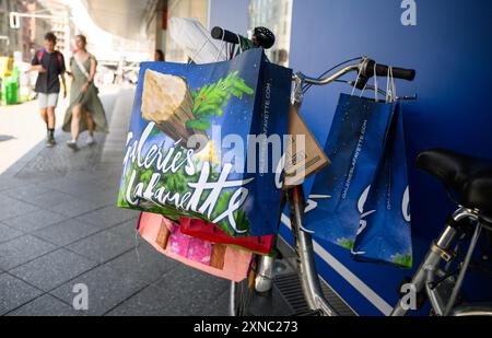 Berlin, Allemagne. 31 juillet 2024. Un vélo rempli de plusieurs sacs à provisions se trouve devant l'entrée principale du grand magasin de luxe Galeries Lafayette sur la Friedrichstrasse à Berlin-Mitte. La chaîne de grands magasins française Galeries Lafayette ferme aujourd'hui sa succursale berlinoise dans le quartier 207. Le Sénat de Berlin envisage d'emménager la Bibliothèque centrale et régionale de Berlin (ZLB) dans le complexe. Crédit : Bernd von Jutrczenka/dpa/Alamy Live News Banque D'Images