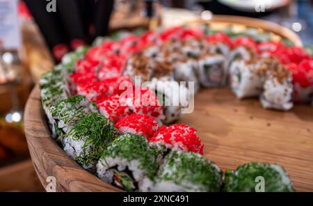 Beaucoup de différents types de sushis sur une assiette en bois. Banque D'Images