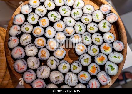 Beaucoup de différents types de sushis sur une assiette en bois. Banque D'Images
