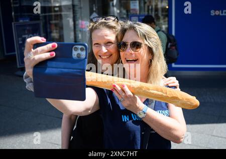 Berlin, Allemagne. 31 juillet 2024. Simone (l) et Alexandra prennent une photo selfie d'adieu avec une baguette devant le grand magasin de luxe Galeries Lafayette sur la Friedrichstrasse à Berlin-Mitte. La chaîne de grands magasins française Galeries Lafayette ferme aujourd'hui sa succursale berlinoise dans le quartier 207. Le Sénat de Berlin envisage d'emménager la Bibliothèque centrale et régionale de Berlin (ZLB) dans le complexe. Crédit : Bernd von Jutrczenka/dpa/Alamy Live News Banque D'Images