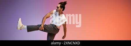 Un jeune danseur afro-américain pose sur un fond dégradé coloré. Banque D'Images