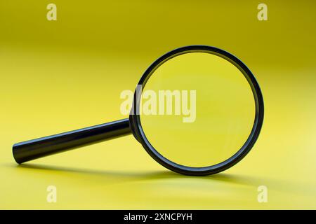Loupe sur fond jaune avec espace personnalisable pour le texte. Banque D'Images