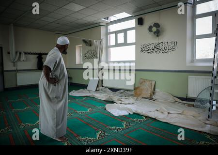 Imam de la mosquée du Centre islamique de Southport Imam Sheik Ibrahim Hussein, regardez les dégâts à l'intérieur de la mosquée après une manifestation alors que les policiers ont subi de graves blessures quand des briques, des pierres et des bouteilles ont été lancées et des voitures incendiées lors de violentes manifestations à la suite d'une veillée en faveur de trois filles tuées dans une attaque au couteau dans un club de vacances sur le thème de Taylor Swift lundi. Date de la photo : mercredi 31 juillet 2024. Banque D'Images