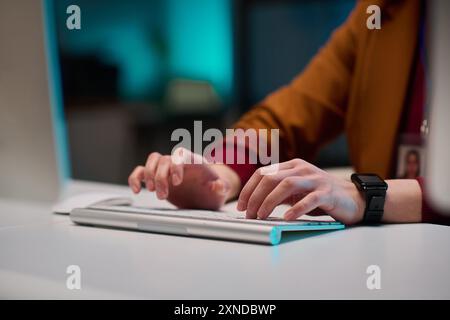 Gros plan des mains féminines tapant sur le clavier d'ordinateur sans fil tout en travaillant au bureau dans l'espace de copie de bureau Banque D'Images