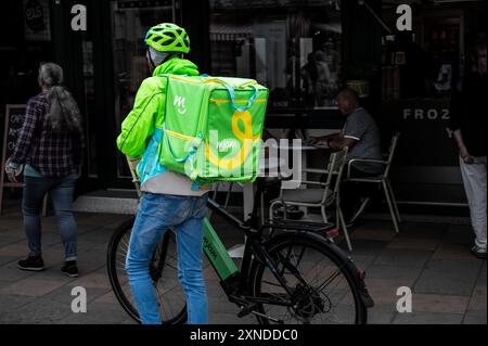 Vienne, Autriche, 23 août 2022. Tourné au marché Naschmarkt, un ouvrier de la société de livreurs mjam. Il descendit de son vélo pour traverser la foule Banque D'Images